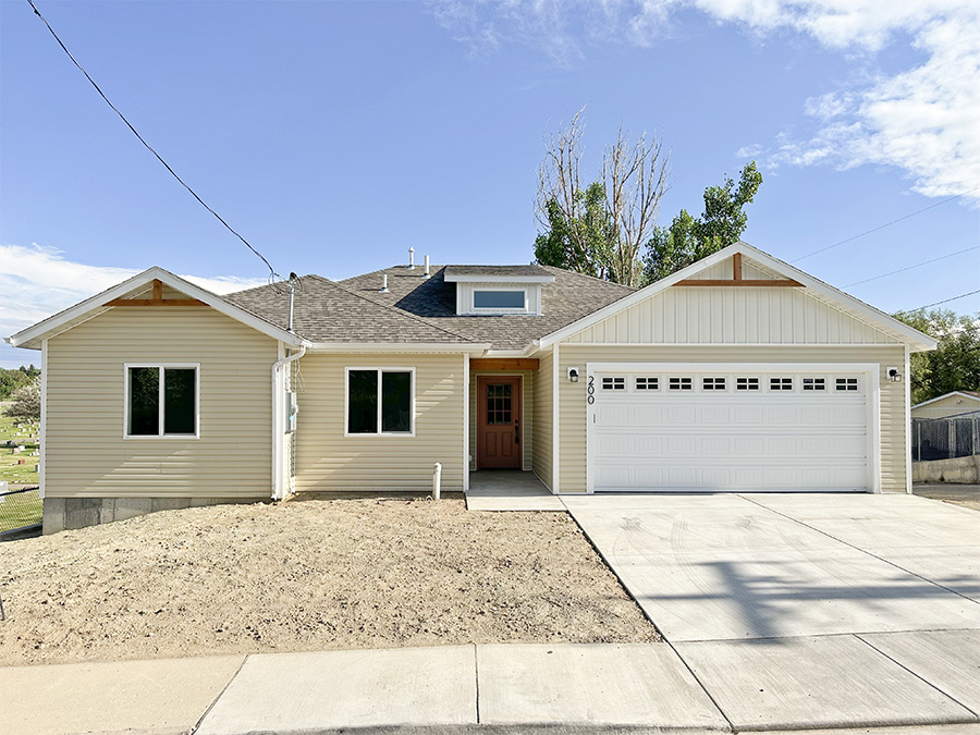 Charming 1-level home with classic tan and white siding and a rusty coral front door
